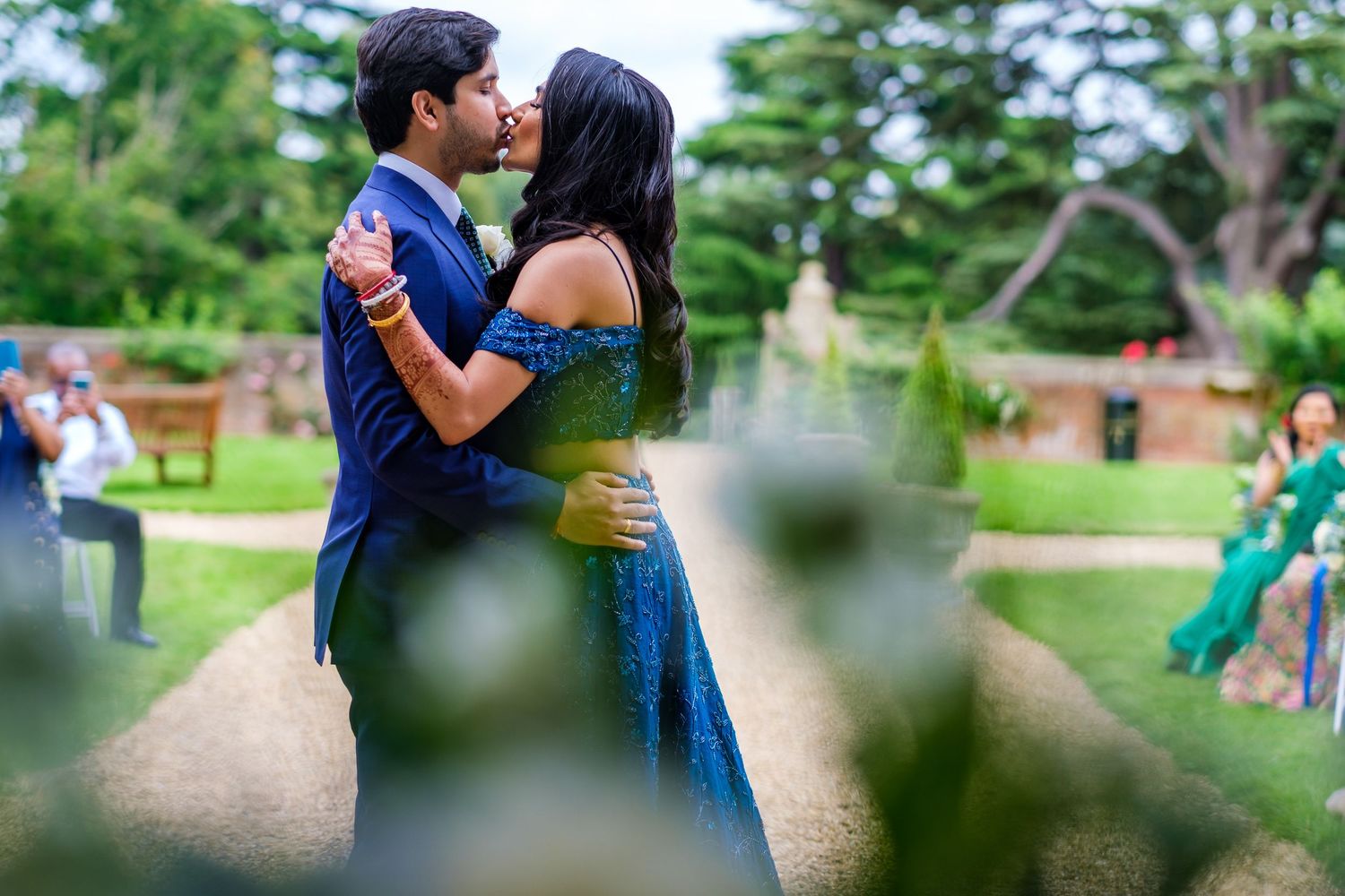 Couple sharing a romantic moment during their wedding celebration in a lush garden setting.