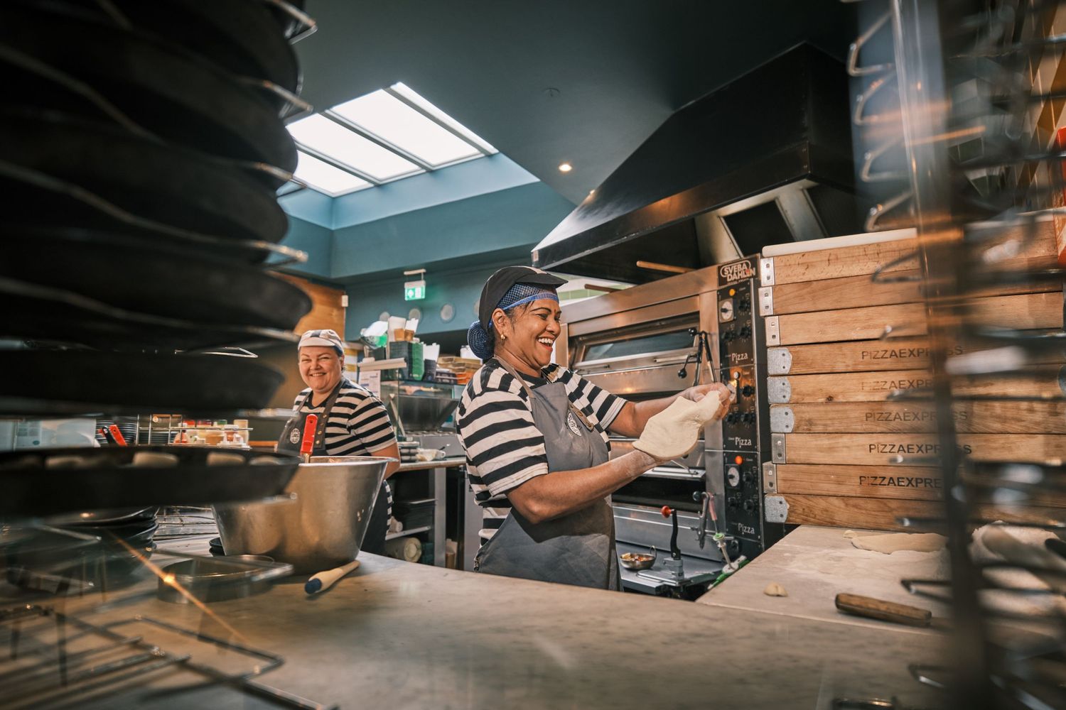 Pizza kitchen interior with skylight showing busy work environment.