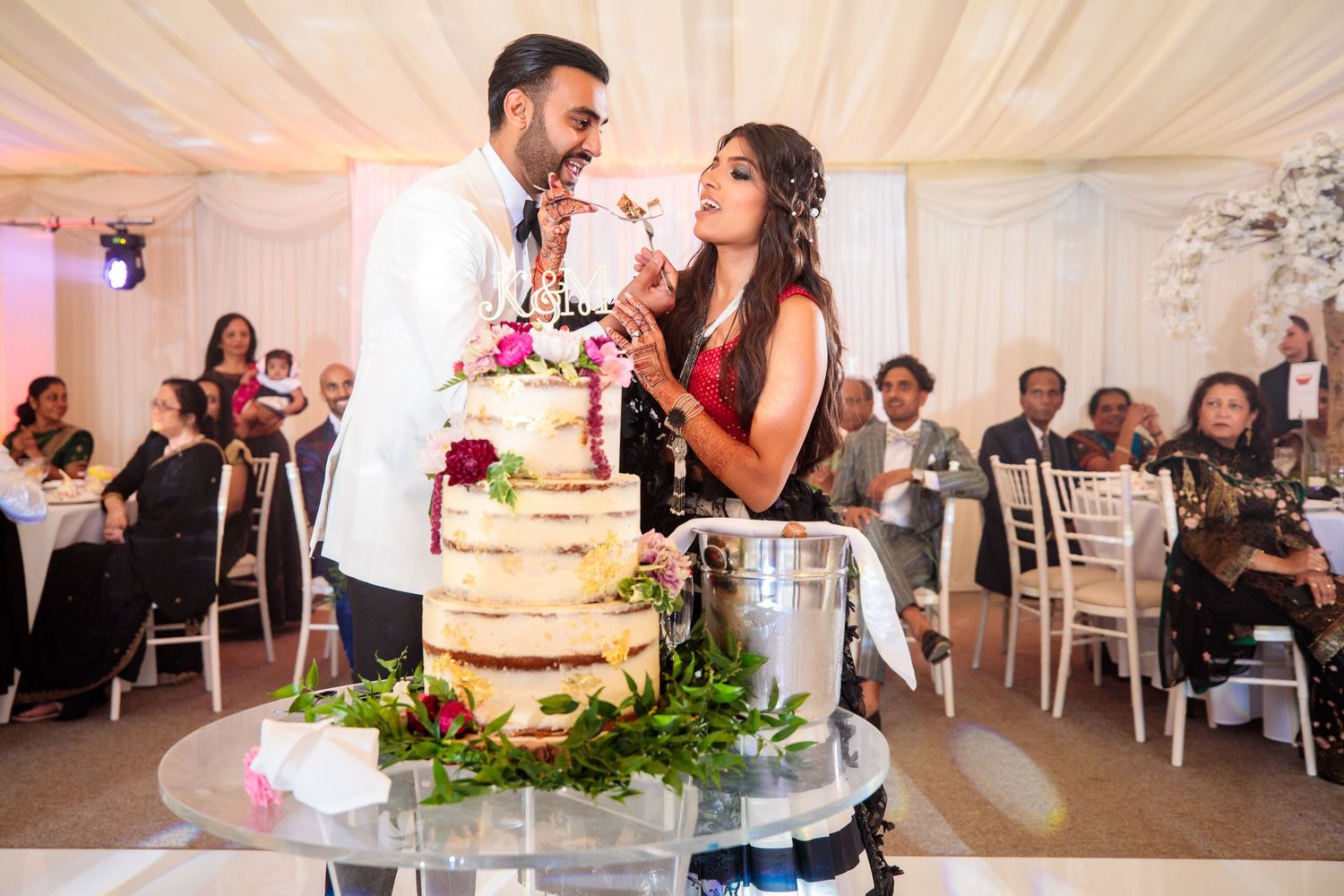 Indoor wedding reception venue with elegant white tent decor and table settings.
