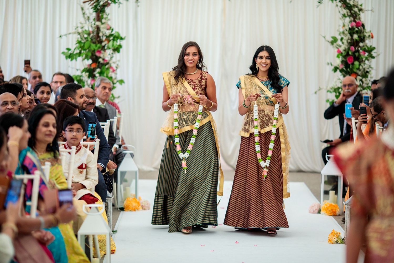 Wedding ceremony setup with white drapes and pink floral arrangements creating an elegant backdrop.