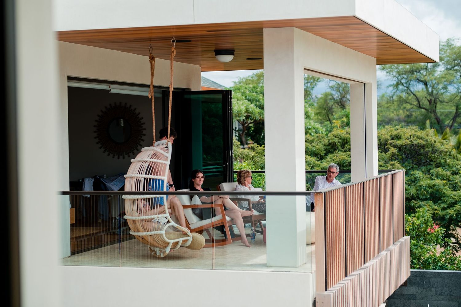 Covered outdoor patio area with white columns overlooking tropical landscaping.
