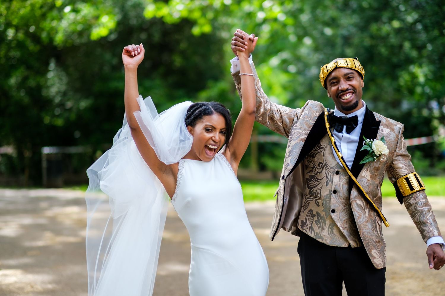 Joyful outdoor wedding celebration with couples dancing and celebrating in a garden setting.