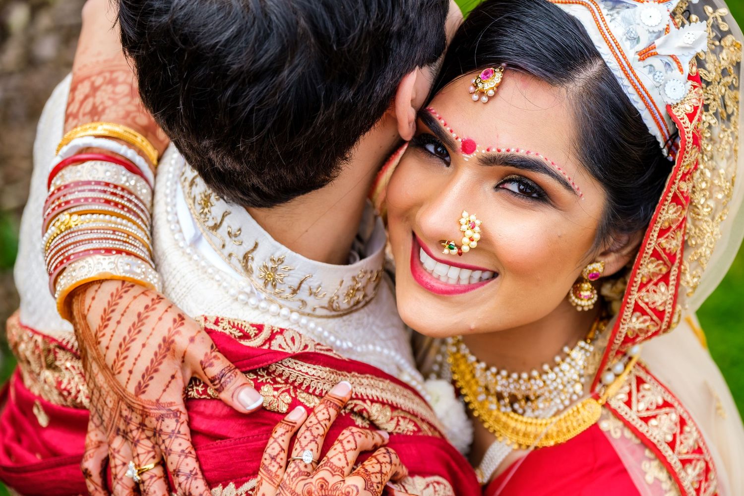 Wedding couple in traditional Indian attire sharing intimate moments during their outdoor photoshoot.