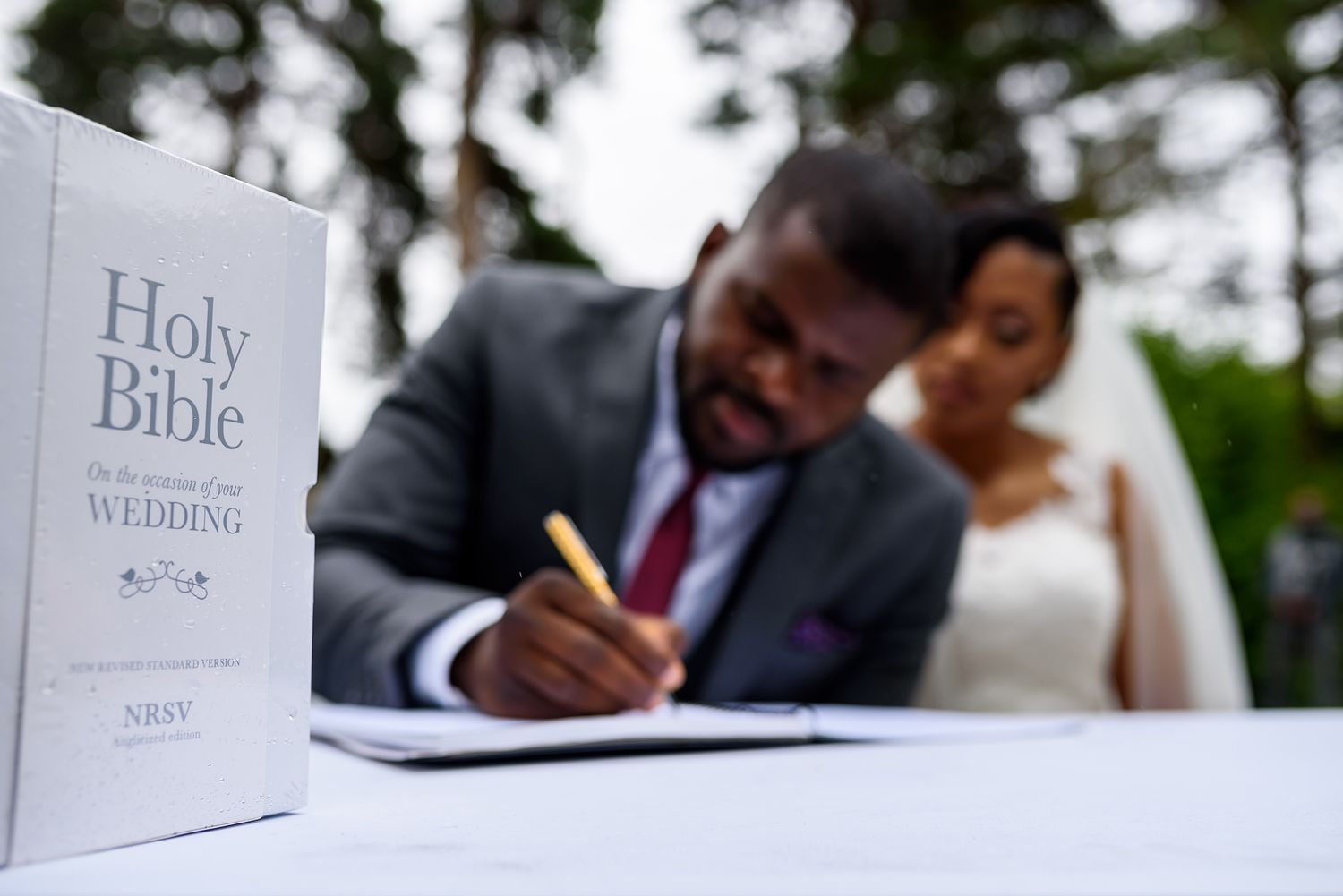 Holy Bible and wedding ceremony materials displayed during an outdoor garden ceremony.