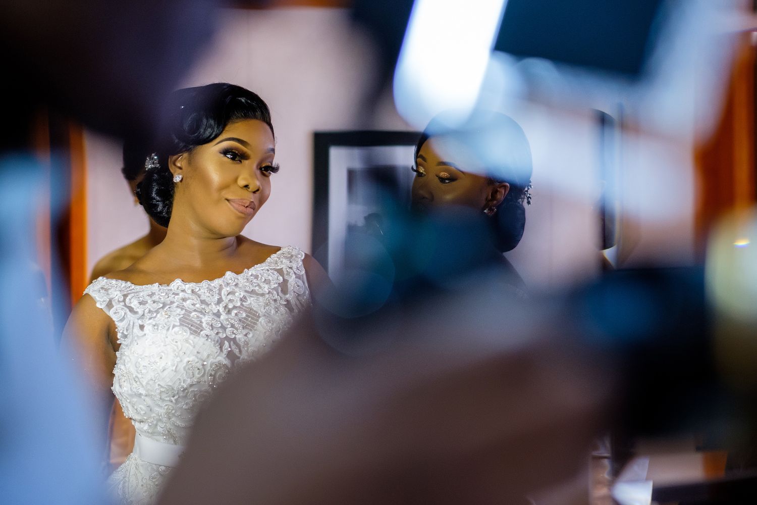 Wedding preparation scene with detailed lace dress in soft focus.