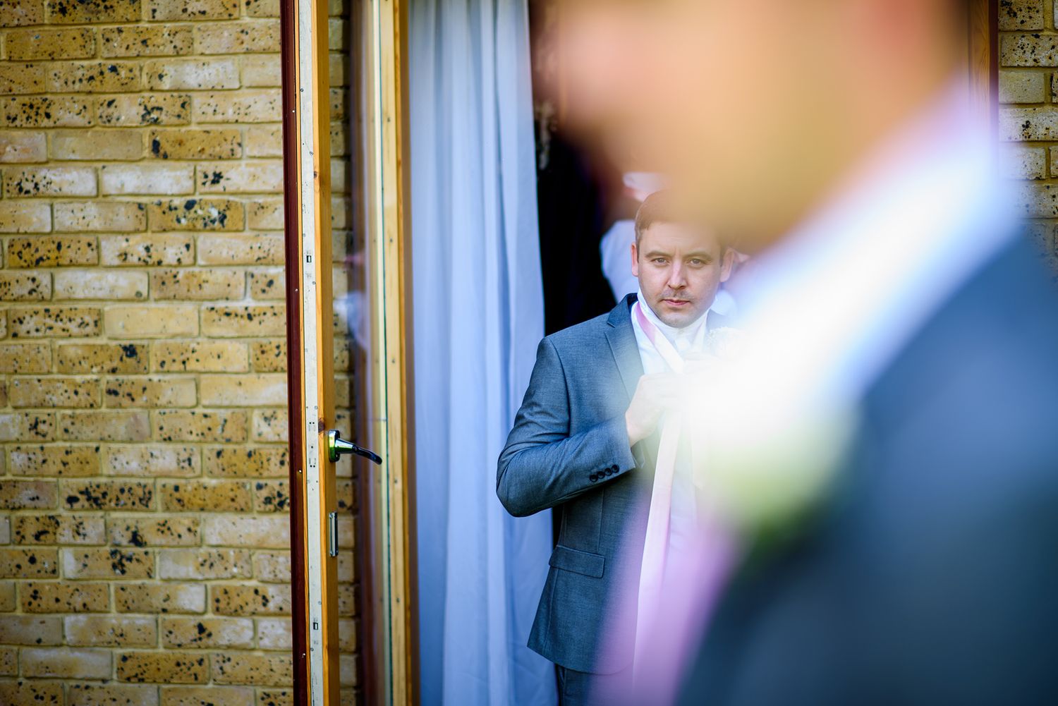 Wedding party standing by a classic brick building exterior.
