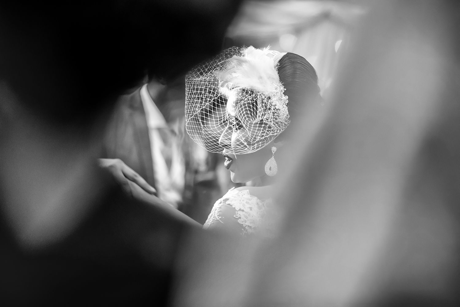 Elegant bridal portrait with soft focus and dramatic lighting creates ethereal effect.