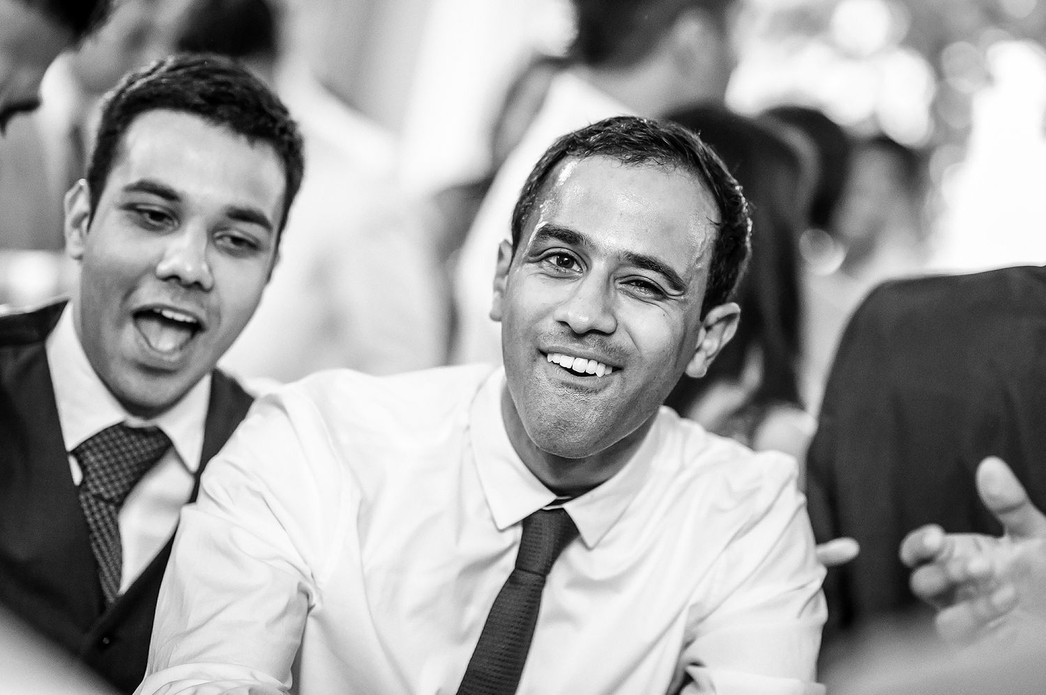 Black and white candid portraits capturing joyful expressions at a celebration.