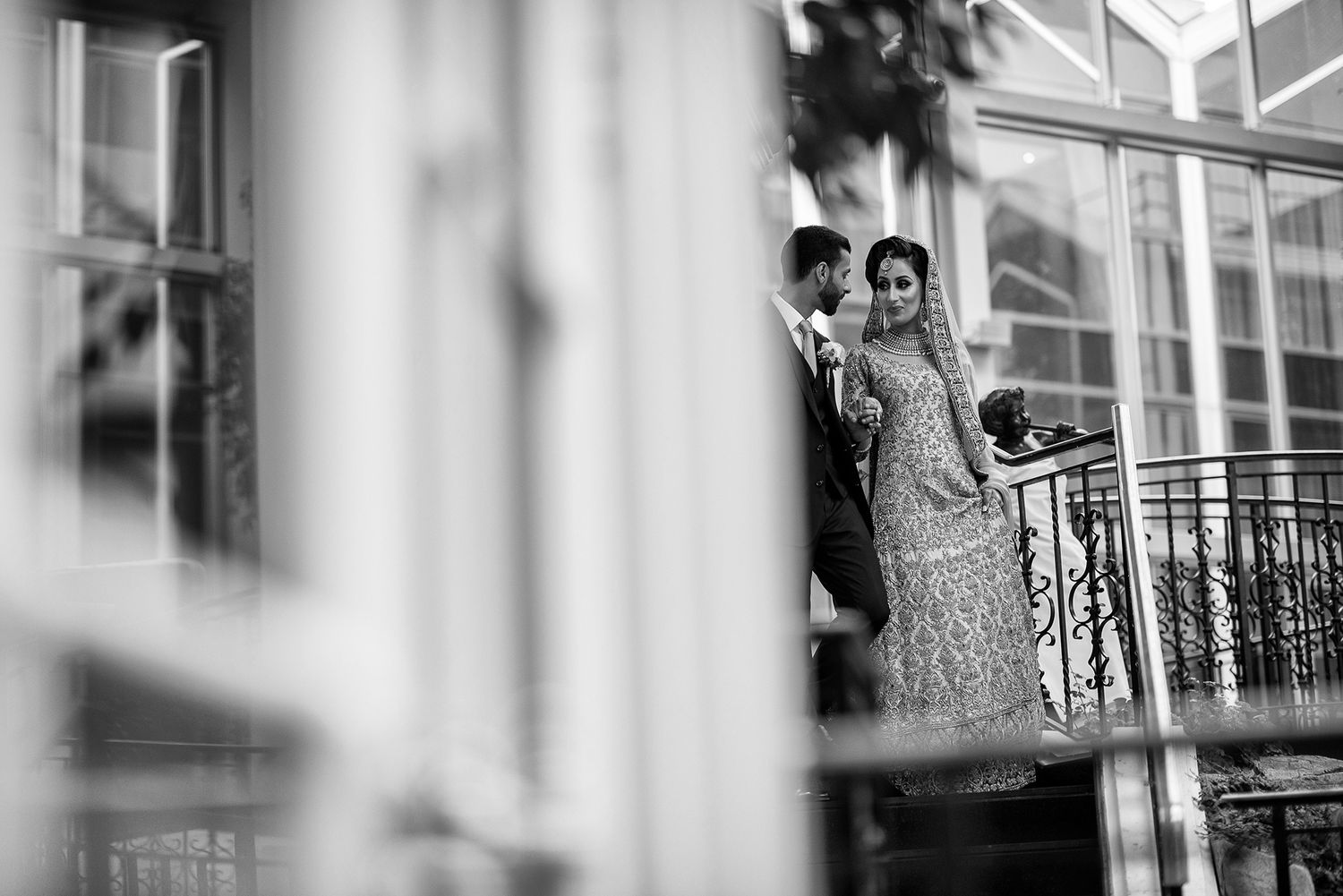 Artistic black and white wedding photography through architectural elements.