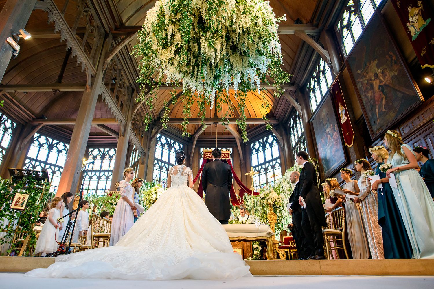 Cathedral-style wedding venue with dramatic architectural details and suspended floral installations.