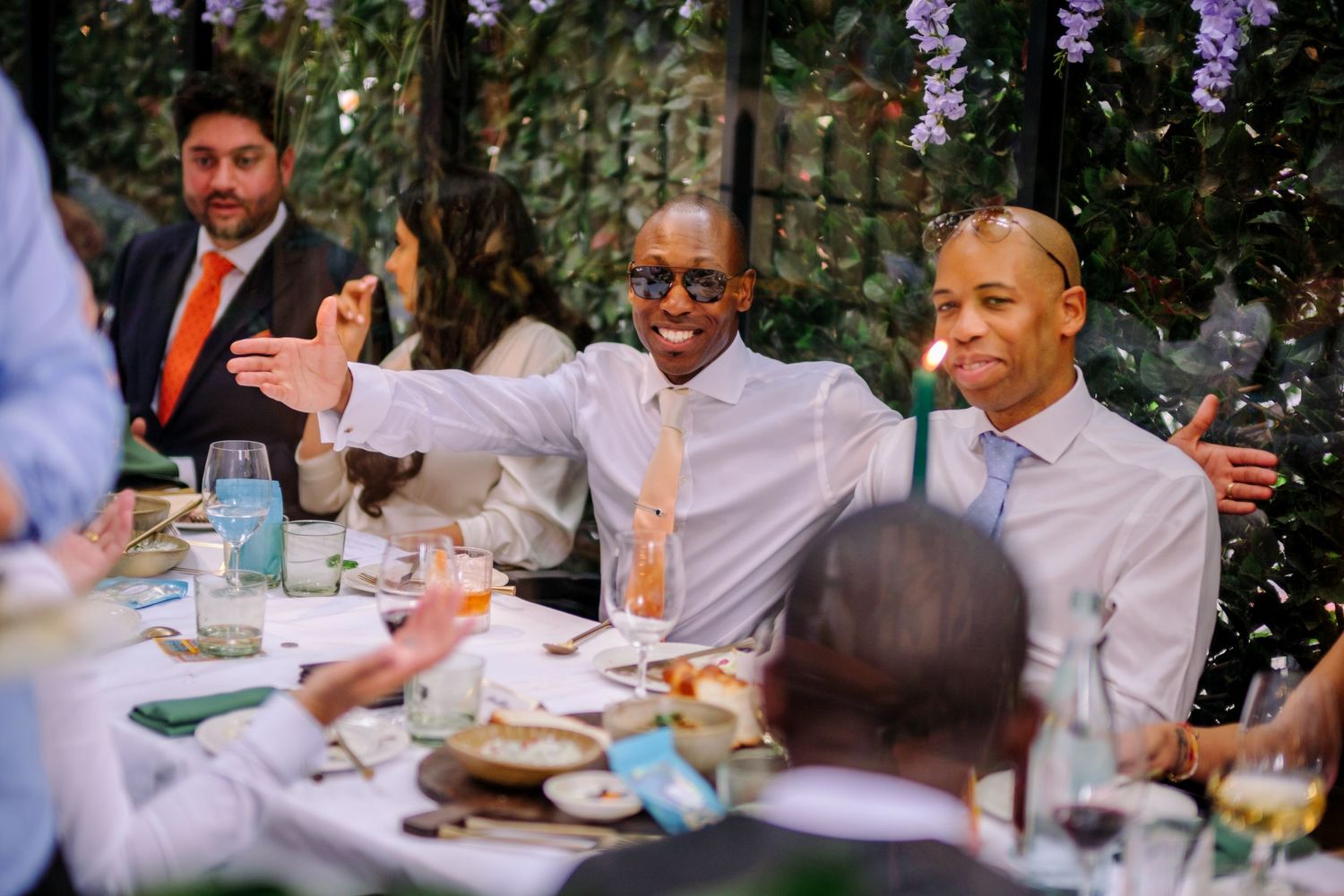 Wedding guests sharing stories and laughs during an outdoor garden reception.