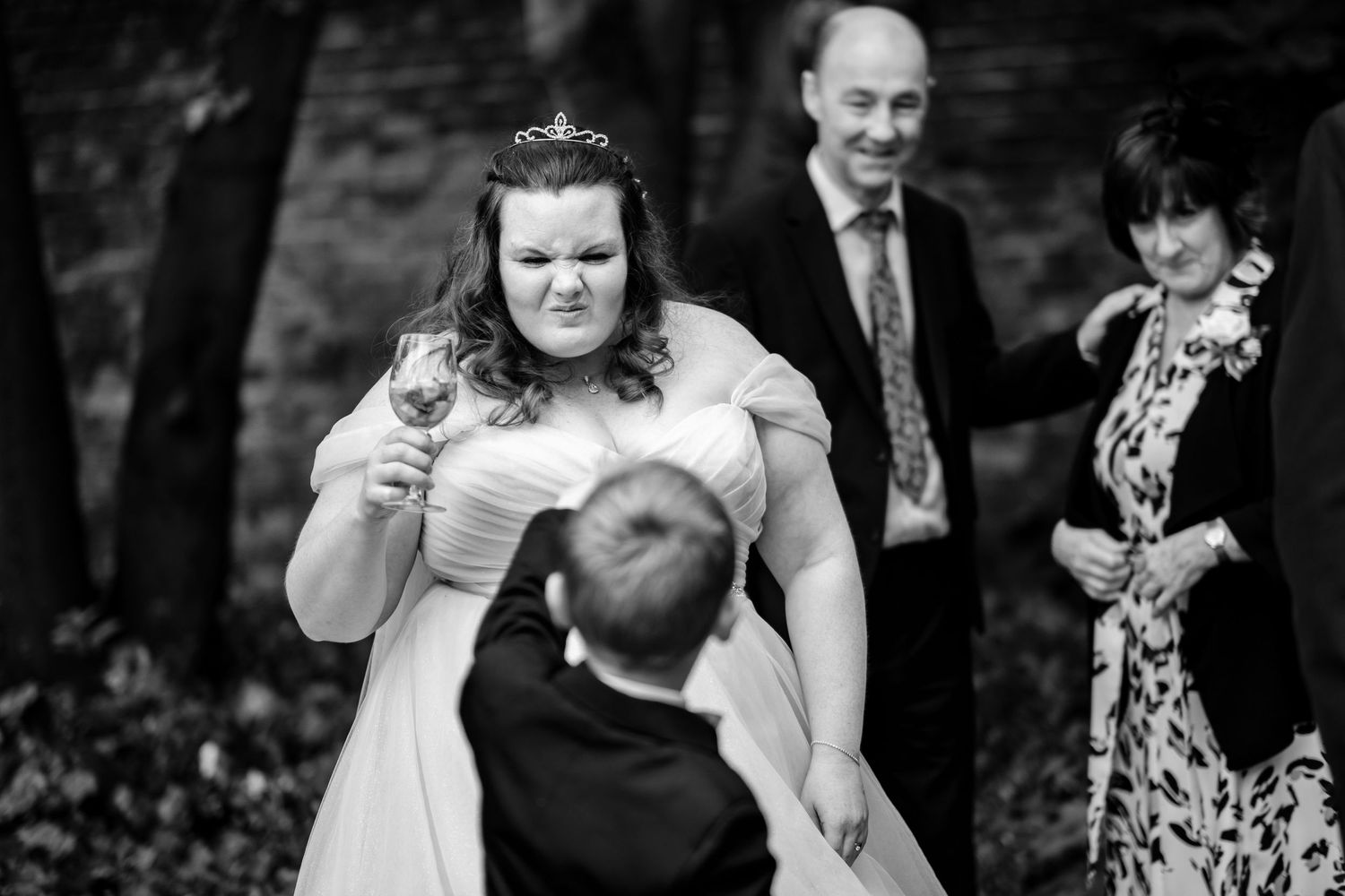 Wedding party celebrating outdoors with natural candid reactions.