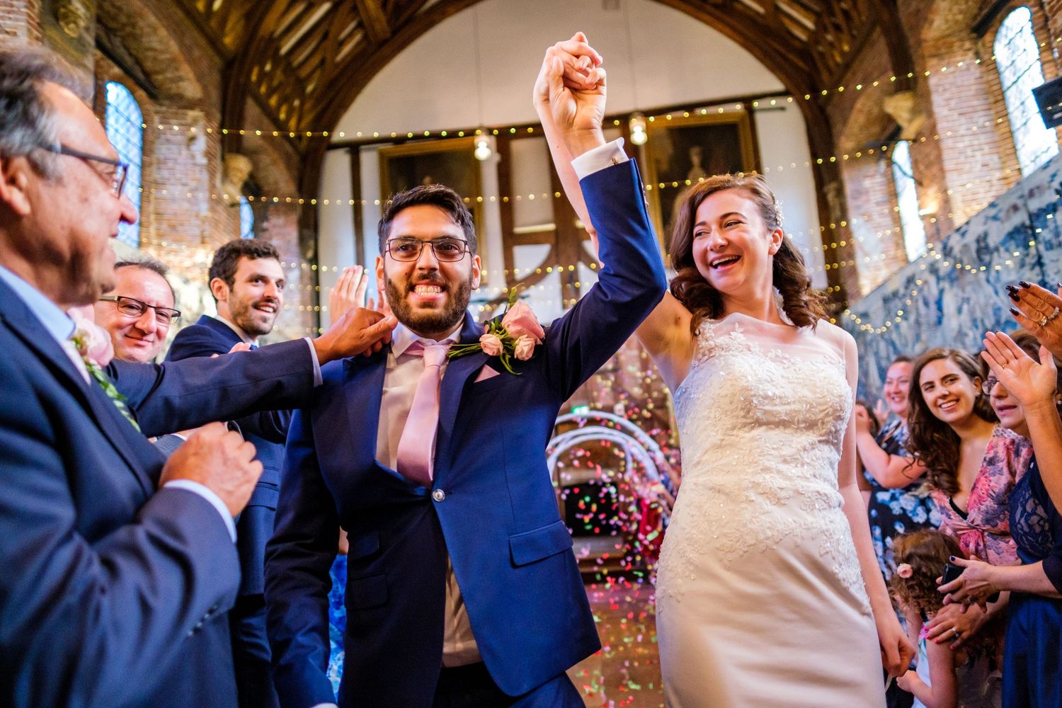 Wedding celebration inside historic venue with exposed brick and string lights.