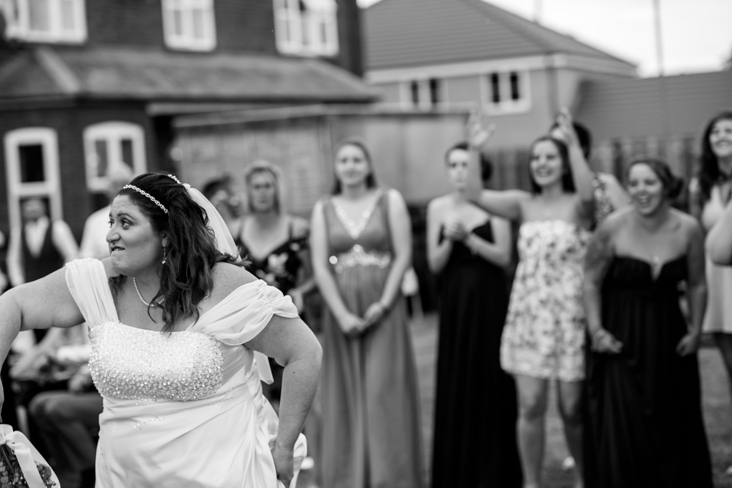 Wedding party poses outdoors in front of residential buildings.