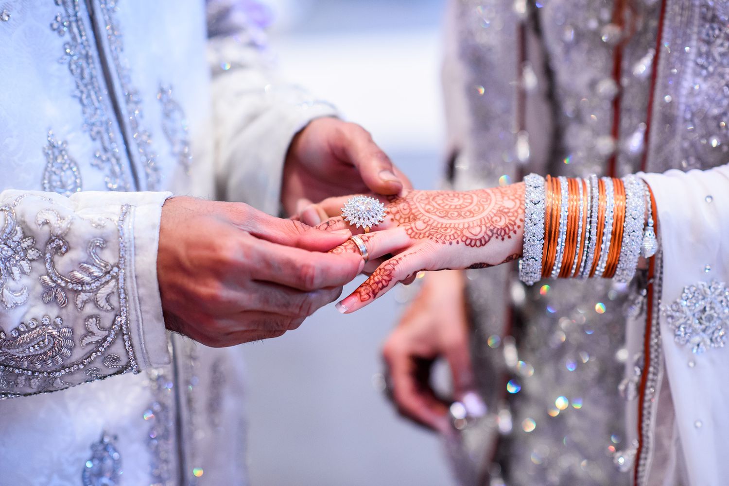 Close-up shots of intricate henna designs and wedding jewelry on hands.
