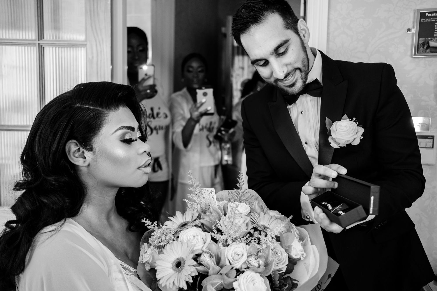 Intimate black and white wedding moment captured with a beautiful bouquet of white flowers.