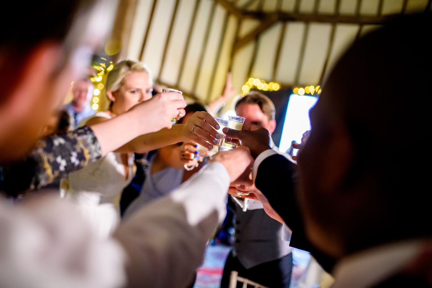 Festive wedding party atmosphere with guests laughing and celebrating together.