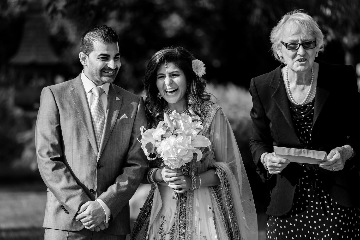 Black and white photograph of wedding guests observing a traditional ceremony.