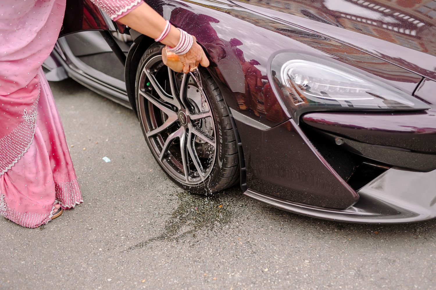 Luxury sports car parked with flowing wedding dresses visible in frame.