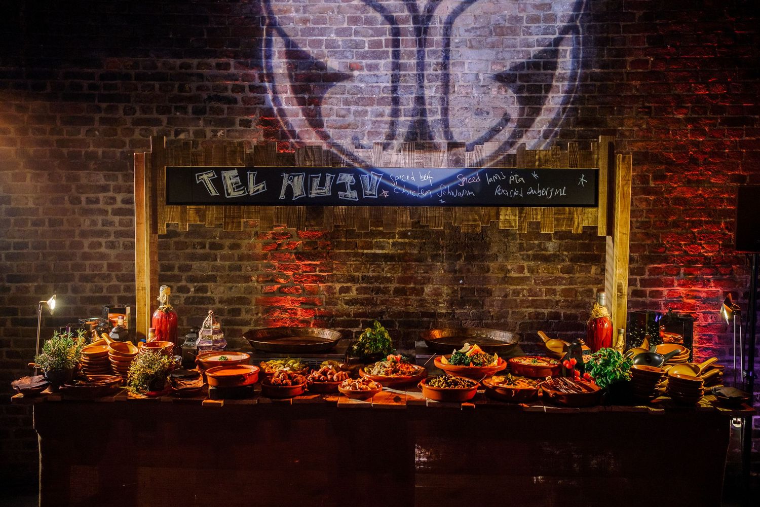 A dimly lit brick wall space decorated with ambient lighting and rustic furniture creates a cozy restaurant atmosphere.