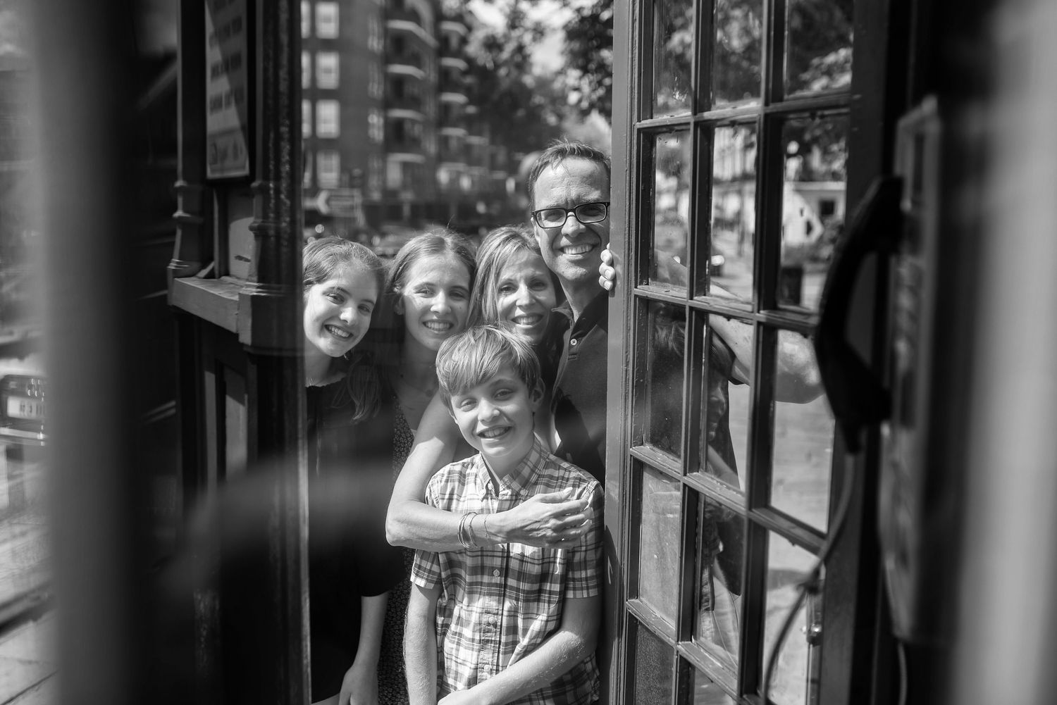 Artistic black and white portrait through glass window reflections with architectural elements.