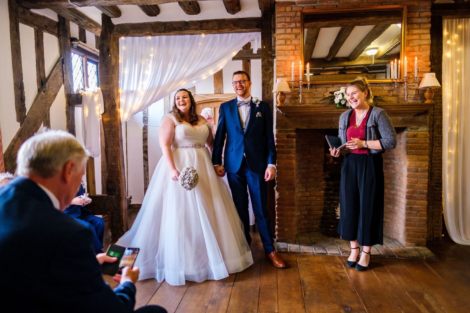 Wedding ceremony taking place in rustic indoor venue with exposed brick walls.