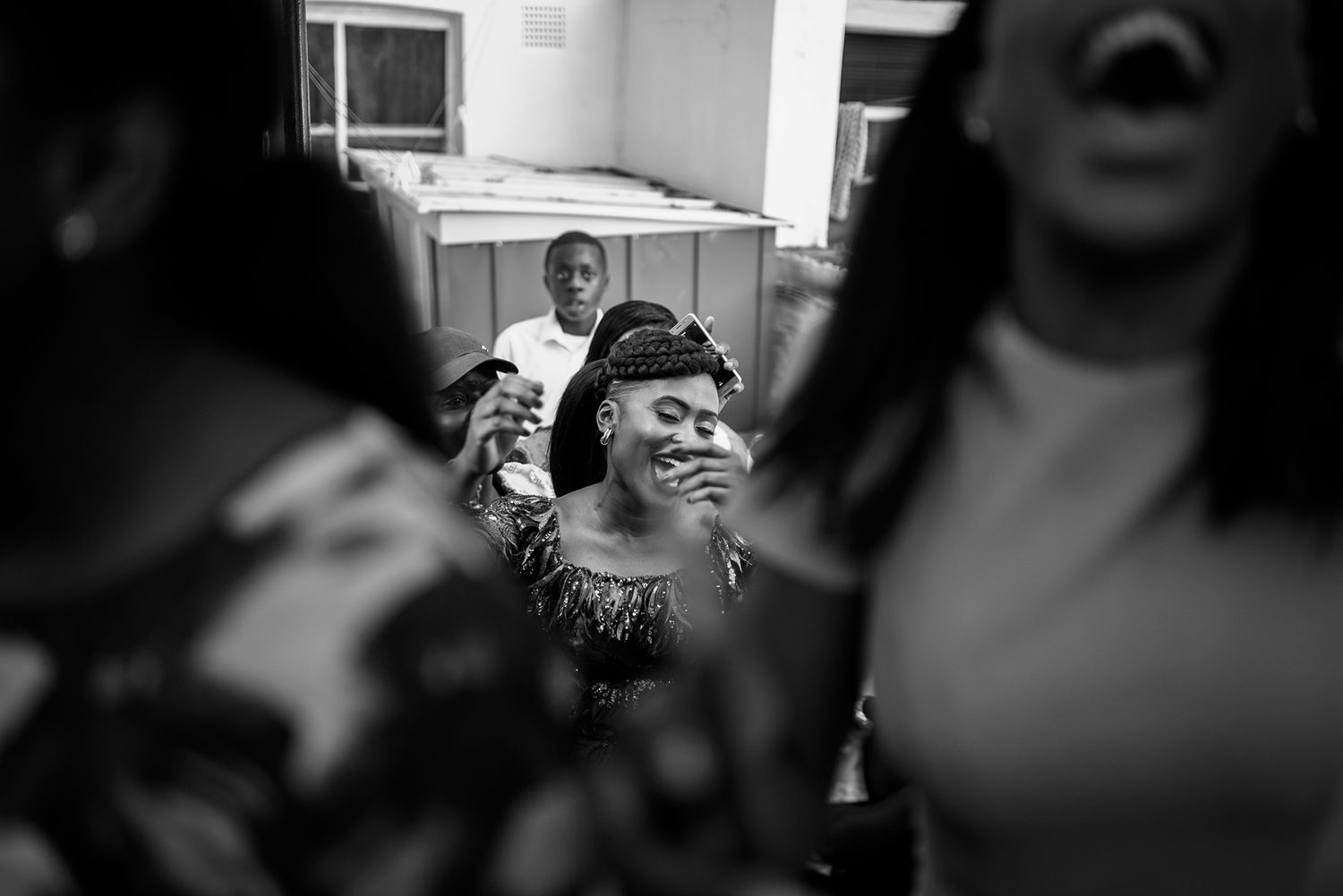 Black and white candid photo capturing natural expressions during a celebration.