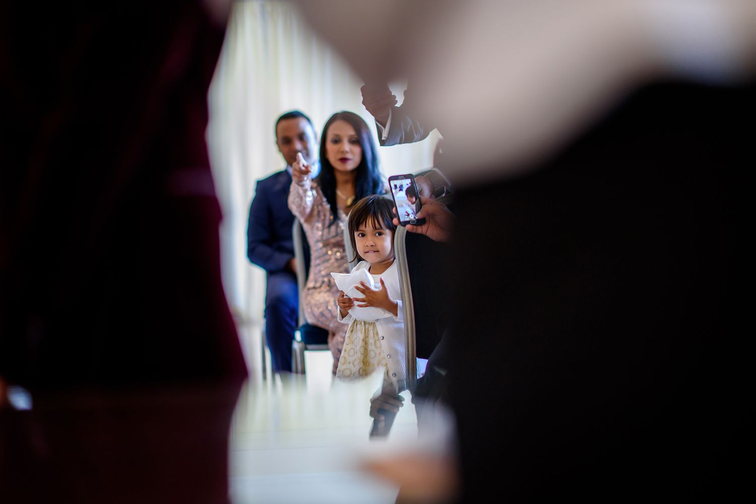 Wedding guests gathered in a bright interior space during a celebration.