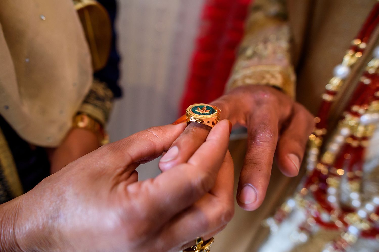 Close-up shots of hands wearing traditional wedding jewelry and decorations.
