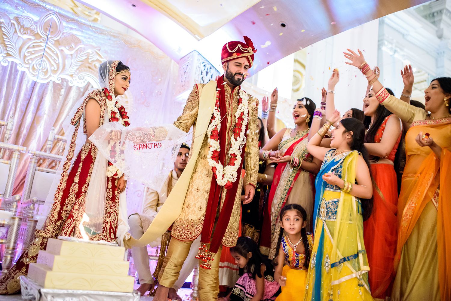 Wedding guests dance and celebrate during a lively Indian wedding reception.