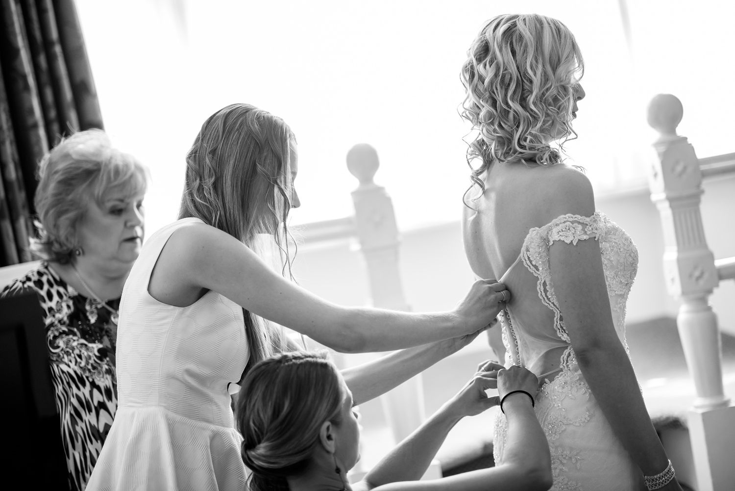 Wedding party members share intimate moments during pre-ceremony preparations.