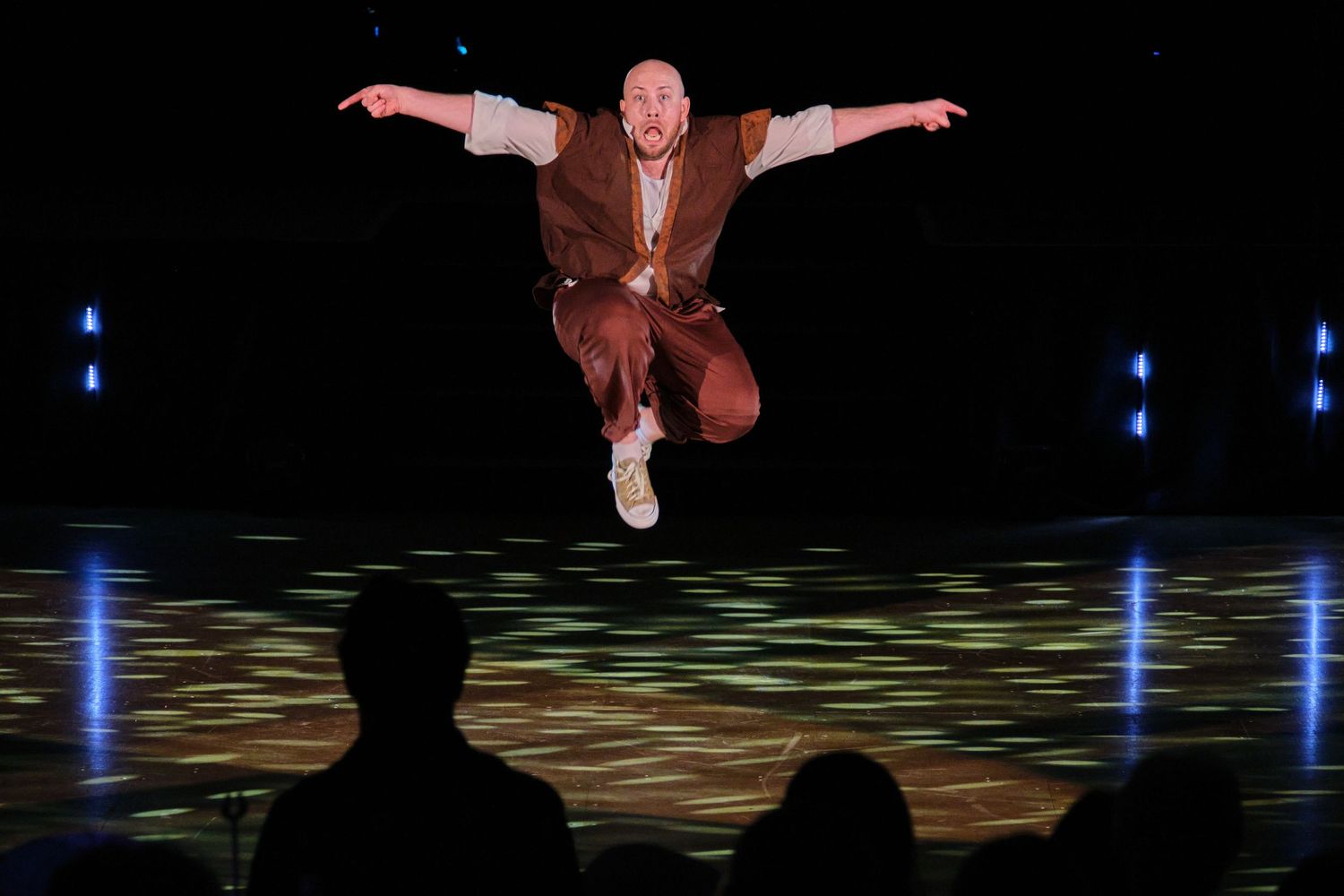 High-energy dance performance on stage with dramatic lighting and dynamic movements.