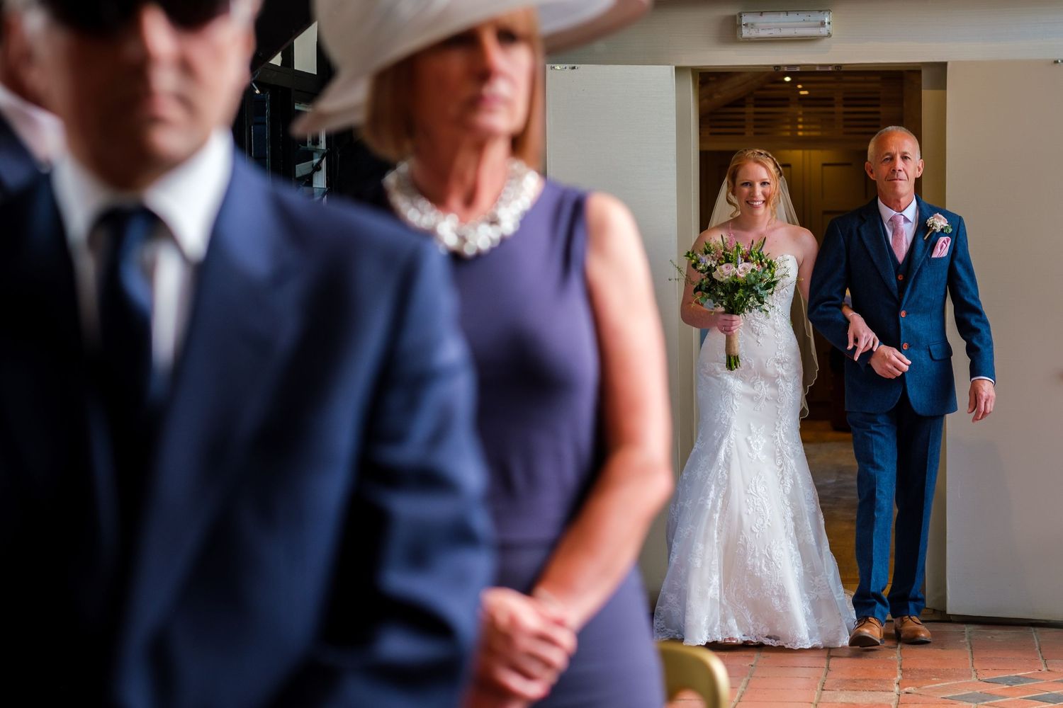 Elegant wedding party dances together in a ballroom during a joyful reception celebration.