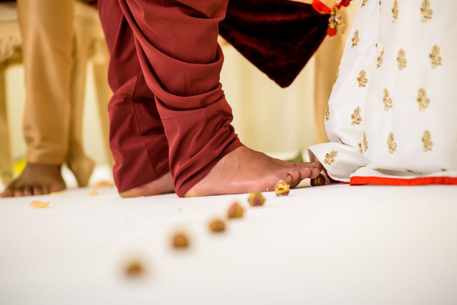 Traditional Hindu wedding ceremony with red and gold decorative elements and ornate pillars.