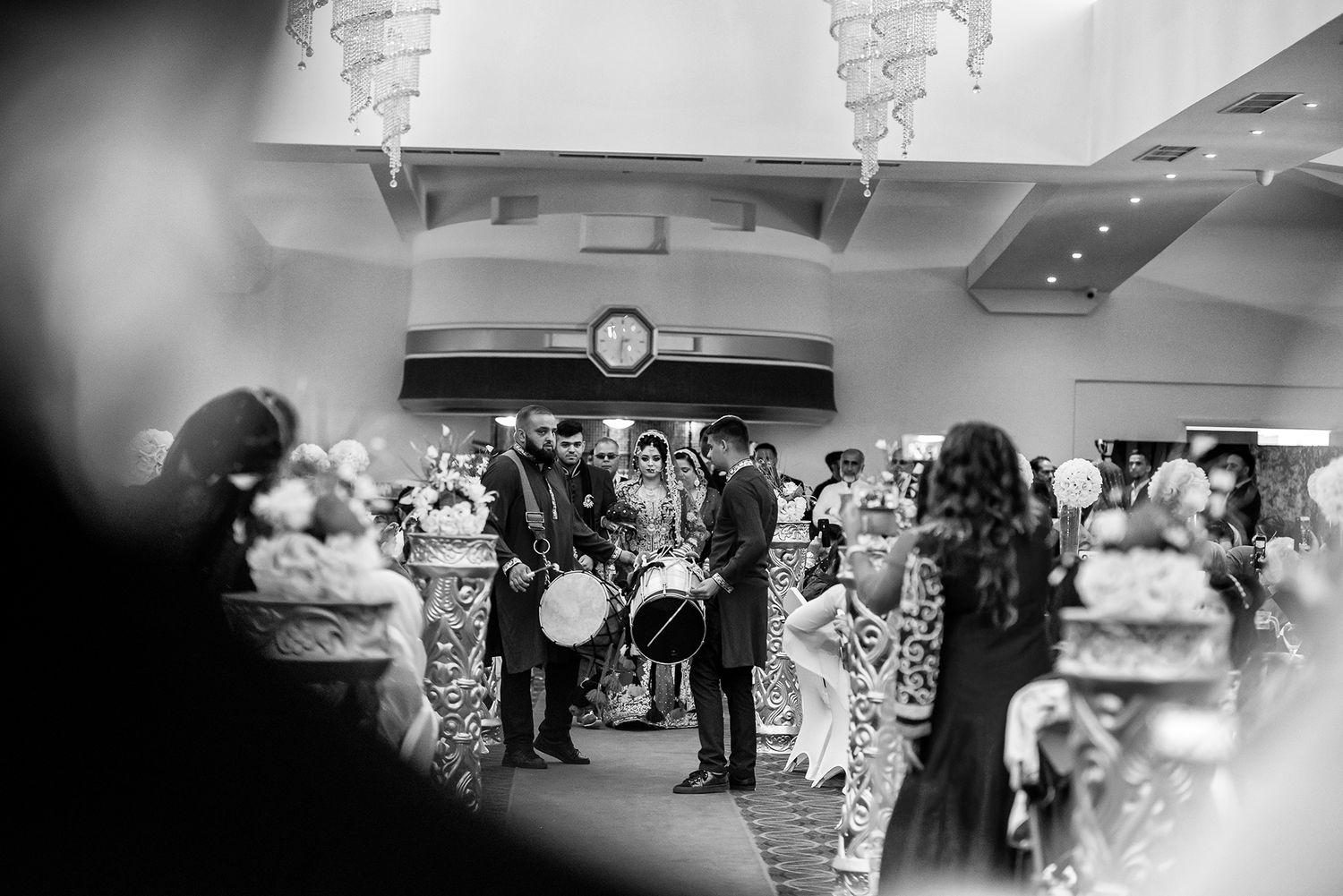 Artistic black and white panoramic shot of an indoor wedding reception venue.