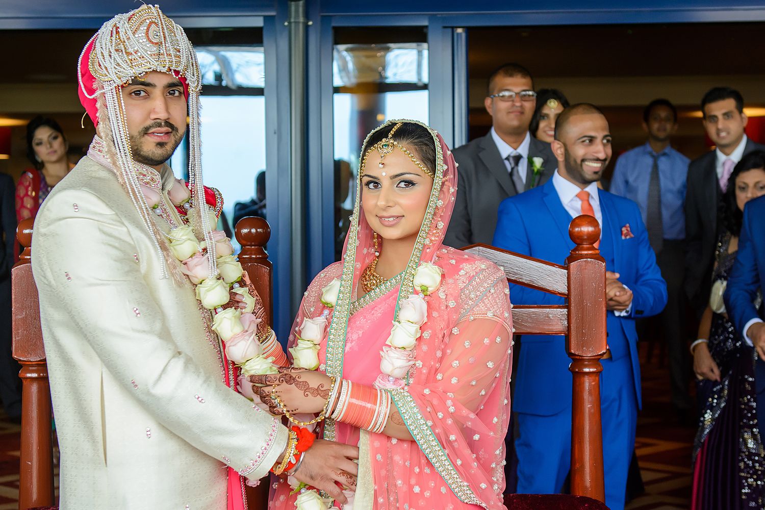 Traditional Indian wedding ceremony featuring colorful pink and gold attire and decorative elements.