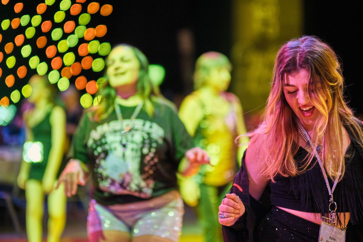 Colorful concert scene with vibrant lighting and energetic crowd during a live music performance.