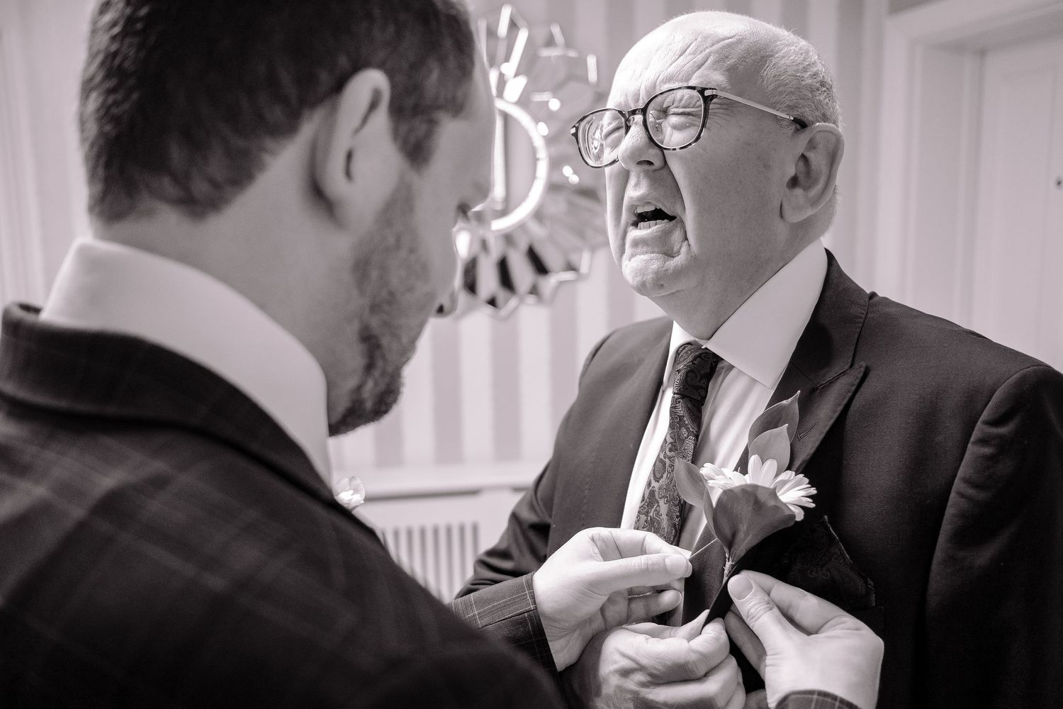 Montage of black and white wedding photos showing candid, emotional moments between people at a reception.
