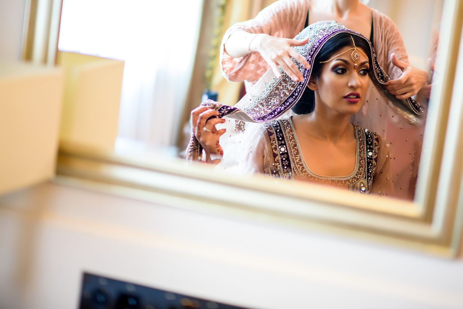 Traditional Indian bridal preparation with ornate jewelry and decorative elements.
