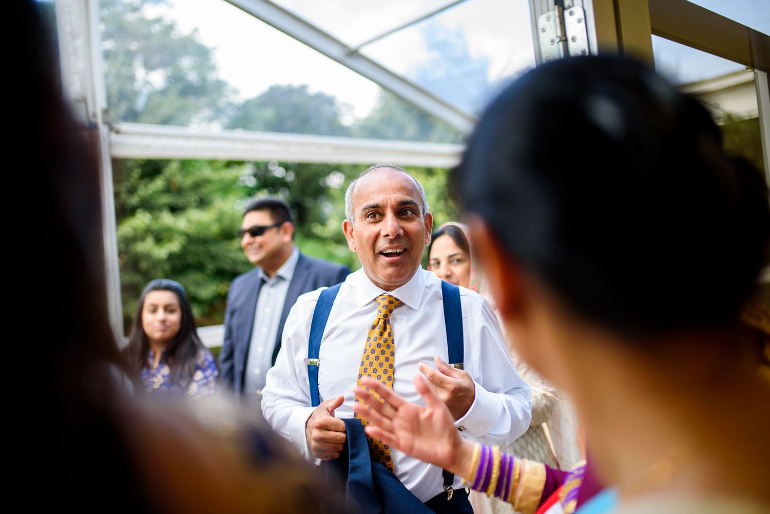 Wedding reception candid moments captured through glass windows.
