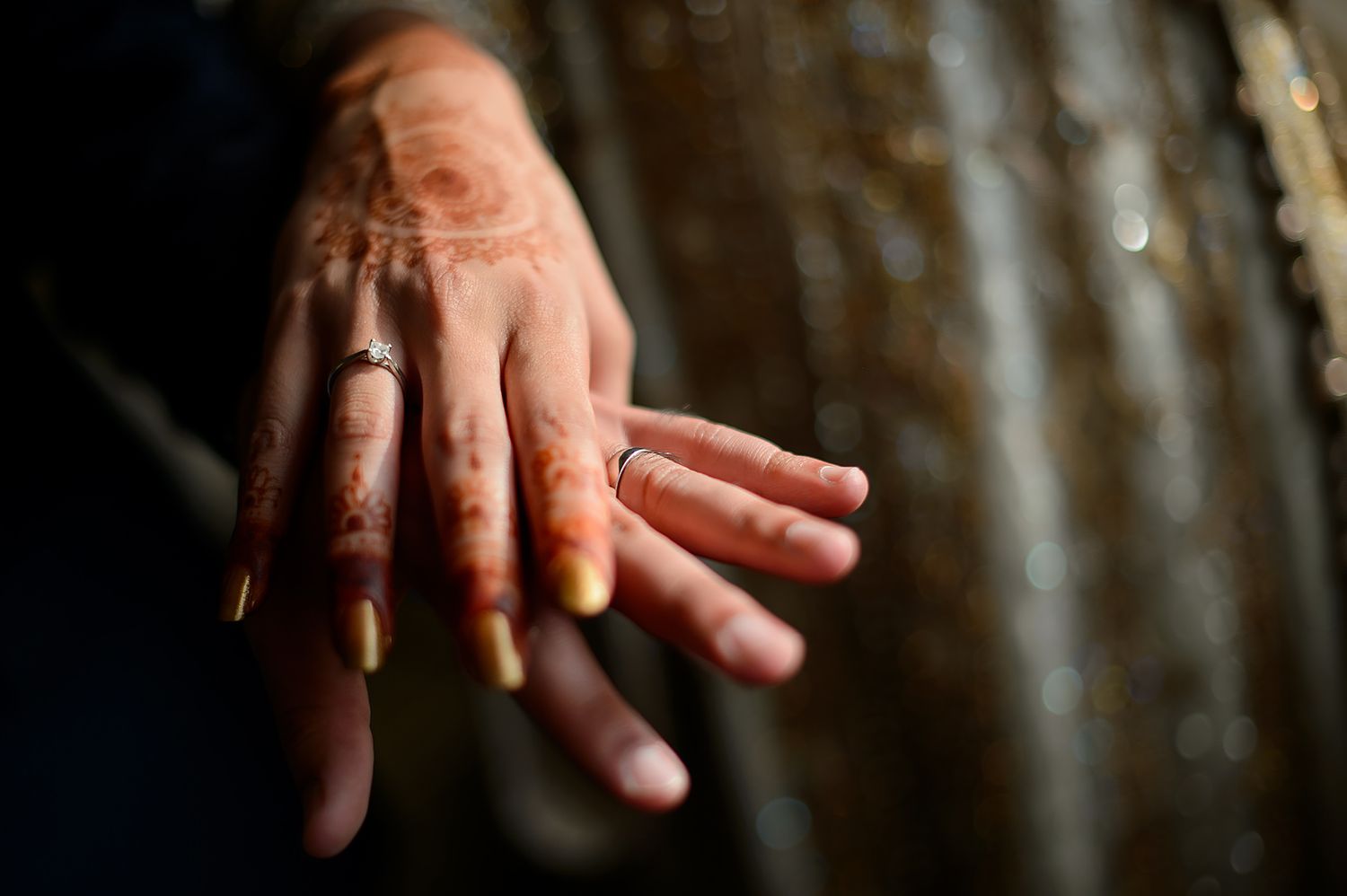 Artful close-up of hands with traditional henna designs and jewelry.
