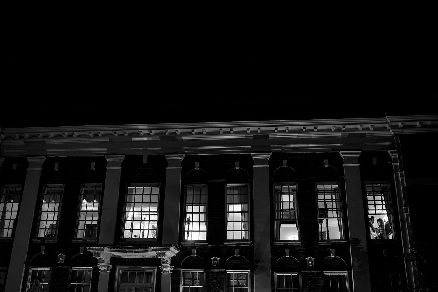 Black and white architectural photograph of a classical building facade with columns and windows.