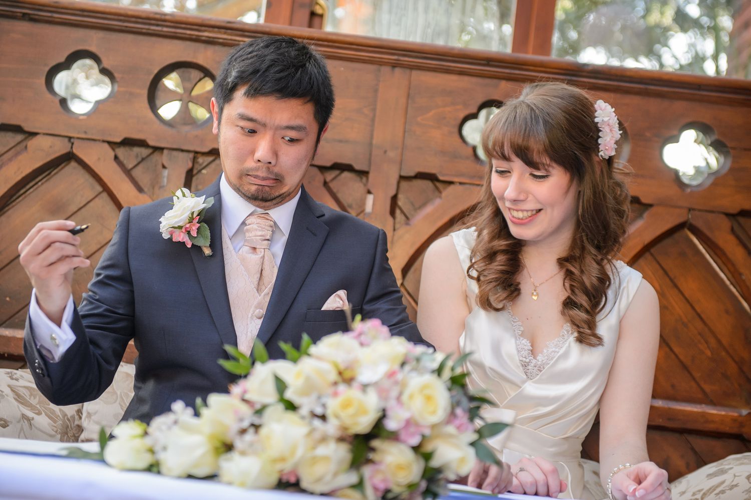 Newlyweds enjoy their first meal together at wedding reception with beautiful flower arrangements.
