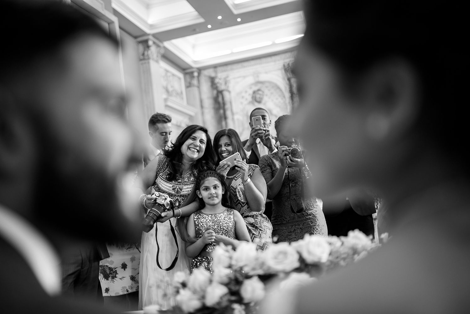 Black and white candid shot of wedding celebration with natural lighting.