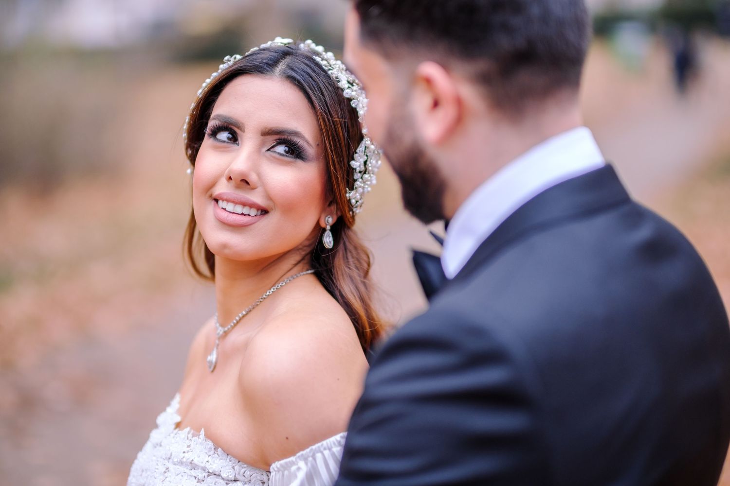 A happy couple shares intimate moments during their outdoor wedding photoshoot at sunset.