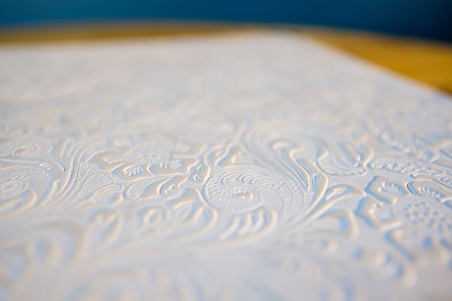 Close-up of textured white embossed pattern on photo album cover.