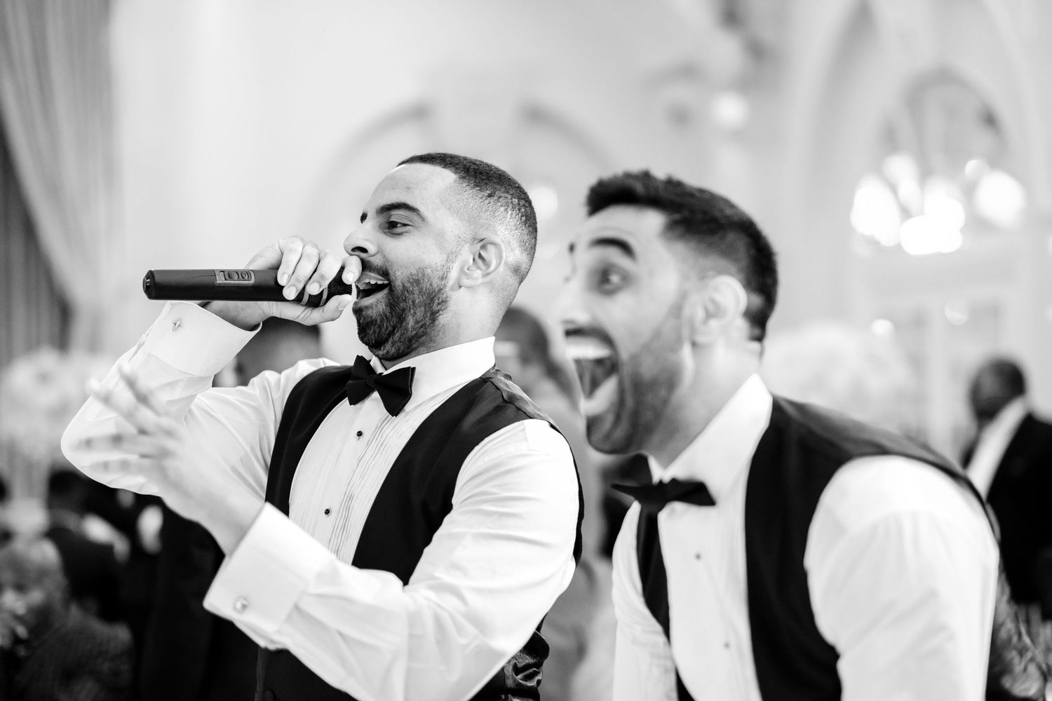 Wedding guests dancing and celebrating together on the dance floor at an elegant reception.