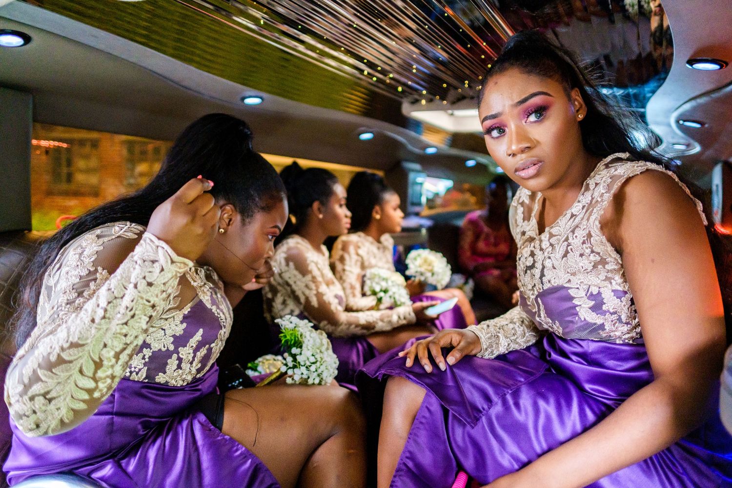 Bridesmaids in purple dresses line up for a coordinated photo at an elegant wedding.