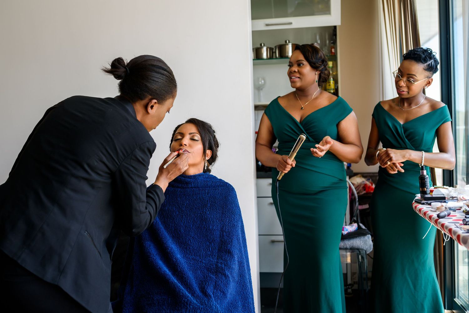 People in formal attire gather during wedding preparations indoors.