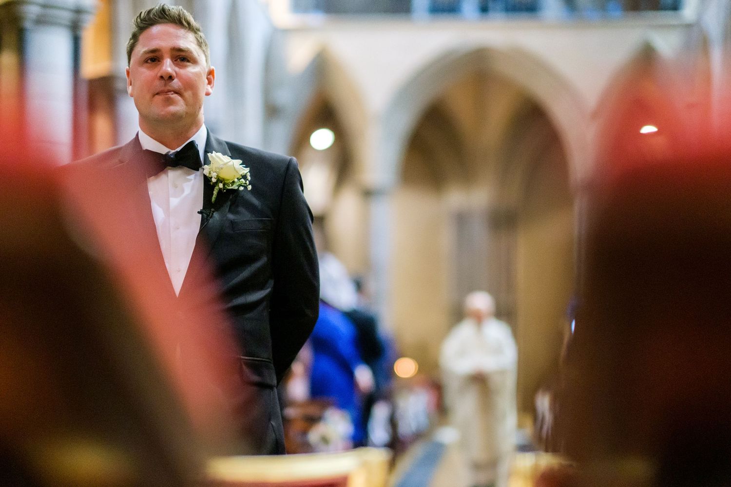 Wedding ceremony taking place in a grand cathedral with elegant stone columns and vaulted ceilings.